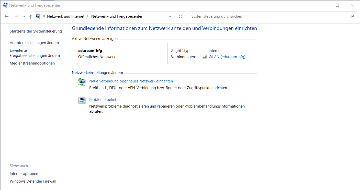 Screenshot of the German "Network and Sharing Center" Windows under the "Network and Internet" section of Control Panel, with an outdated aspect like Windows XP; on the left there is a panel with the options Home, change the adapter settings, change advanced sharing configuration. On the right, the name of eduroam-hfg in bold, near the description access type (internet), followed by "Connection" and four ascending bars, the first two green and repeating "WLAN (eduroam-hfg)". After that a menu with two options: set up a new connection or network, represented with an icon of a screen above a pipeline with a green plus sign, and troubleshoot problems, represented as a window representing zooming in between the pipeline and the screen